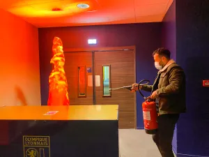 atelier-extincteur-sensibilisation Homme utilisant un extincteur lors d'un atelier de sécurité incendie