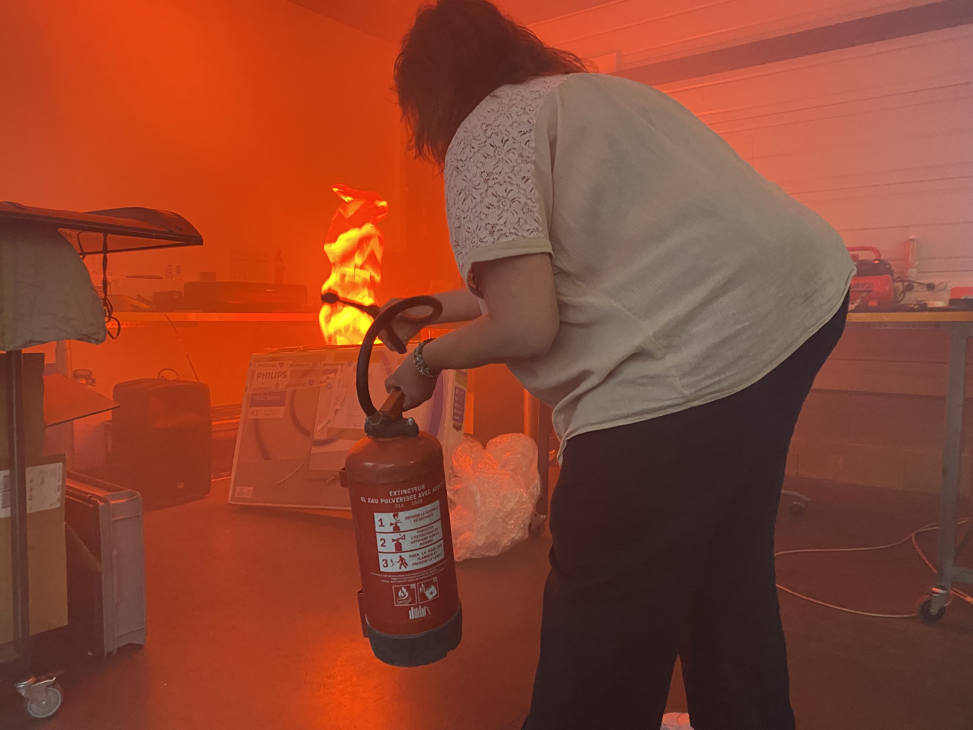extincteur-utilisation-incendie Personne utilisant un extincteur dans une salle enfumée