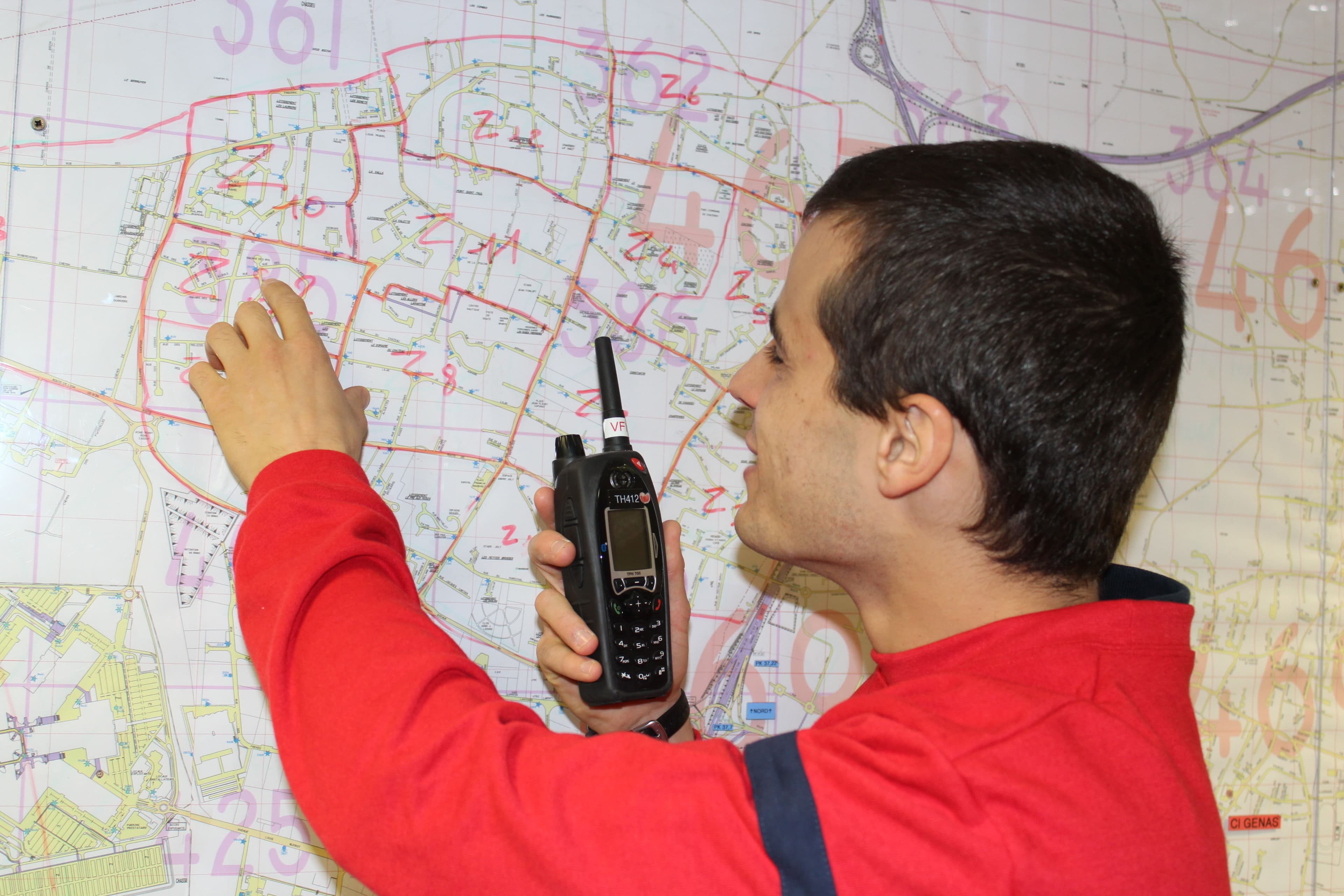 formation-incendie-radio-carte Personne utilisant une radio devant une carte de sécurité incendie